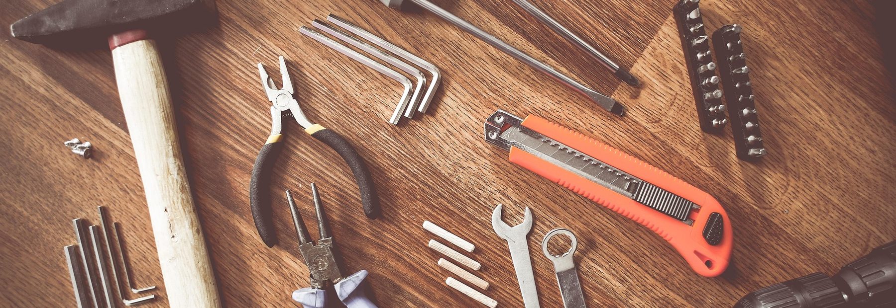 Contractor's tools laid out on a wooden work surface